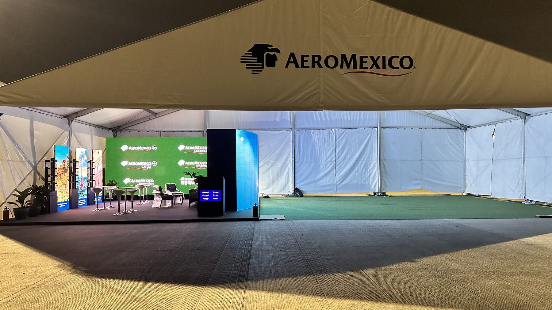 Montaje de stand de Aeroméxico con pantallas y mobiliario de marca