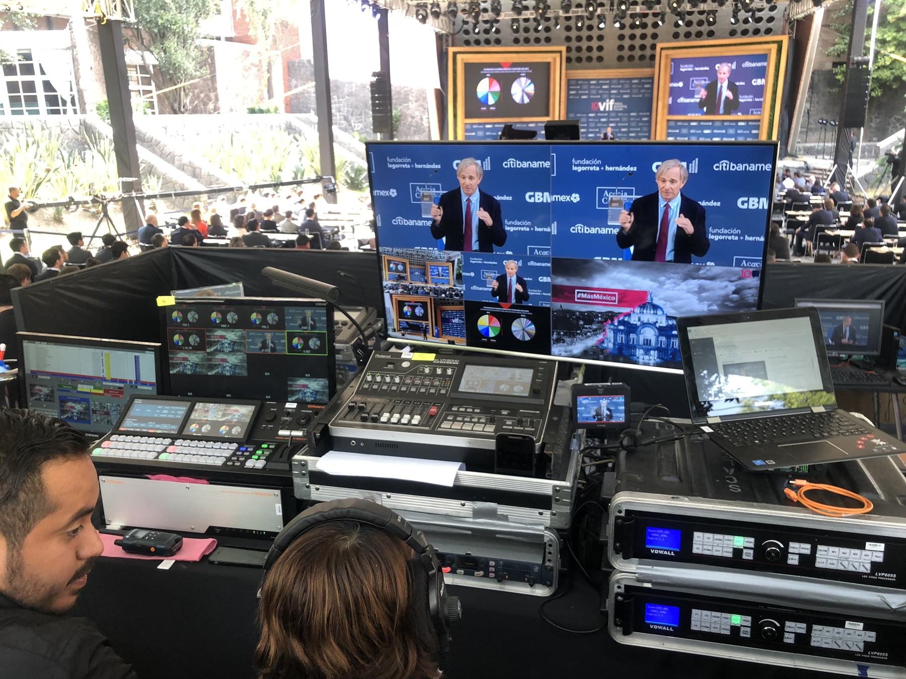 Cabina de control de video con switcher, monitores y procesadores durante un foro corporativo