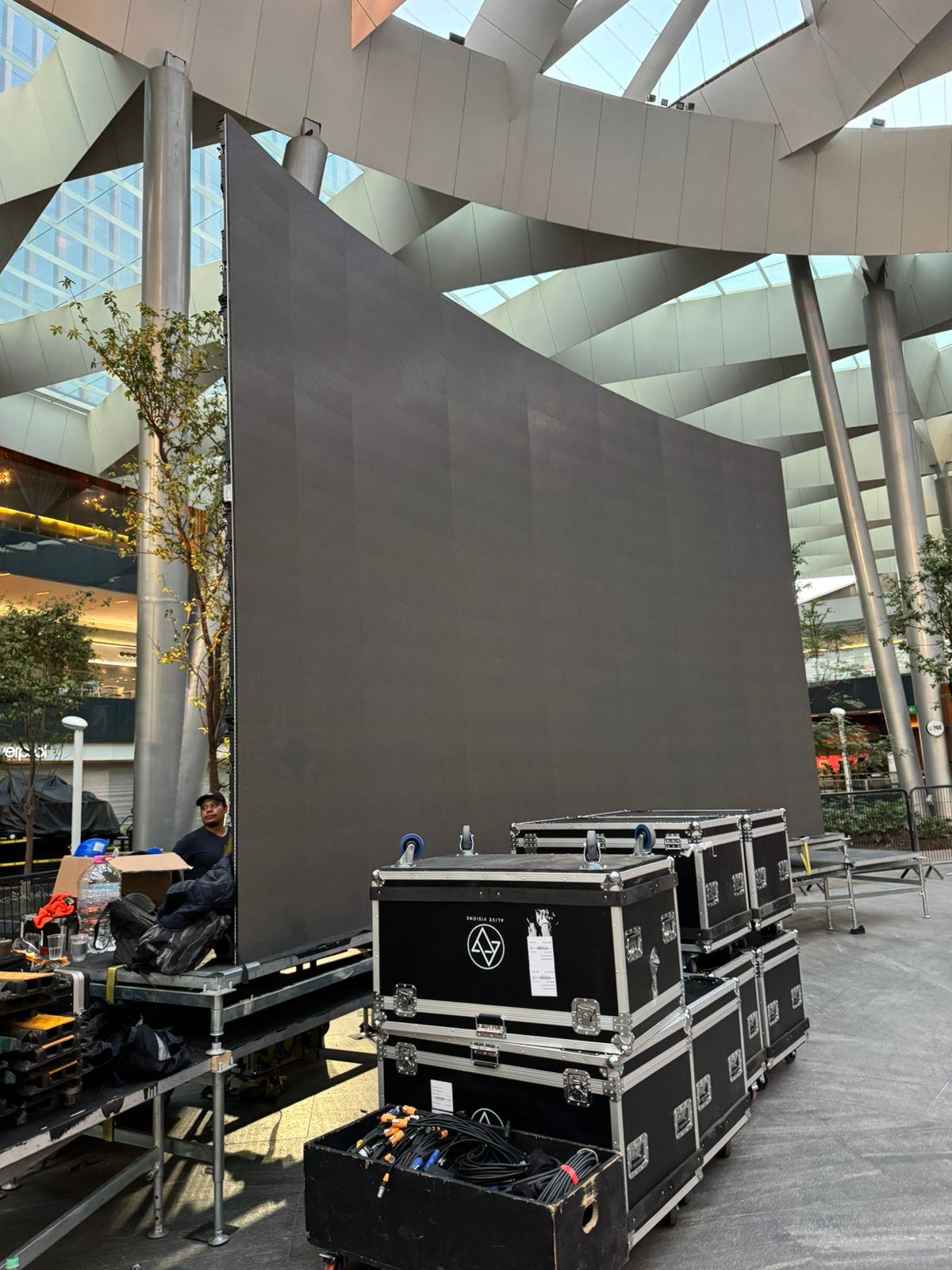 Muro LED de gran formato armado por VideoDesign, apagado, junto a los cases de equipo antes del evento